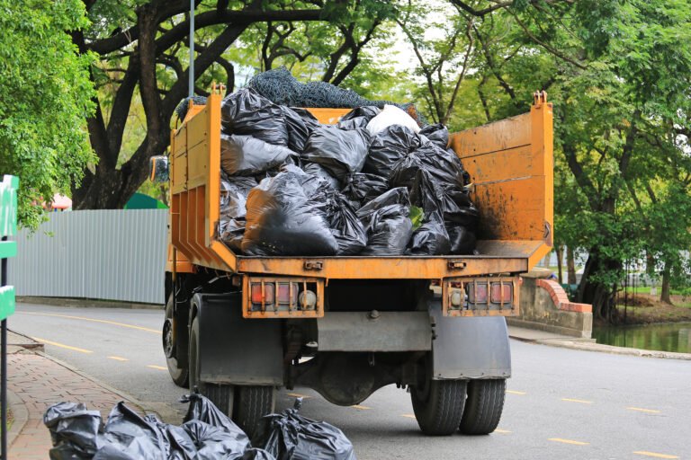 Garbage Truck with loading waste in park garden.